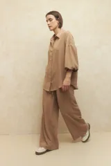 Camisa beige de manga larga con botones a tono.