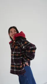 Buzo canguro oversize con capucha y cuello alto, confeccionado con paños de lana estampados.