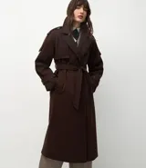Trench coat largo color marrón chocolate, confeccionado en tejido tipo paño, con solapas amplias, cierre frontal cruzado con cinturón de la misma tela para anudar y detalles de trabillas en los hombros y puños.