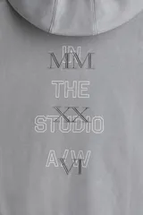 Sudadera con capucha y bolsillo canguro, confeccionada en algodón pesado con efecto lavado en tono gris claro. Presenta un estampado vertical minimalista en el pecho con números romanos y texto.