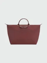 Bolso de mano tipo tote de la línea Le Pliage One de Longchamp, en color bordó. Presenta un diseño minimalista con cierre de cremallera superior, solapa con botón a presión y asas cortas de cuero.