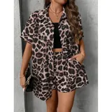 Conjunto de dos piezas compuesto por una camisa de manga corta con cuello italiano y cierre frontal de botones, y un short con cintura elástica y bolsillos laterales. Ambas prendas presentan un diseño estampado de animal print.