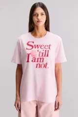 Remera de algodón color rosa claro, corte regular, con cuello redondo y manga corta. Presenta un estampado frontal en rojo con texto y una frambuesa.