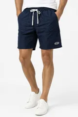 Short negro de poliéster de corte recto, con cintura elástica con cordón de ajuste blanco, bolsillos laterales y pequeño logo bordado en el lateral izquierdo.
