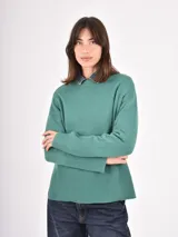 Buzo de tejido de punto color verde, con cuello redondo, mangas largas con puños acanalados y diseño holgado con ruedo acanalado.