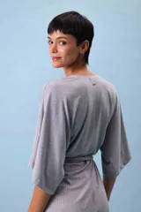 Conjunto de dos piezas (camisa y pantalón) de tejido acanalado gris, con camisa estilo kimono de manga ancha y cuello V cruzado, ajustada a la cintura con un lazo de tela.