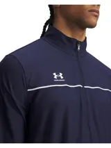 Conjunto deportivo Under Armour Challenger compuesto por una chaqueta con cierre frontal y bolsillos laterales, y un pantalón con cintura elástica y cordón interno. Ambas piezas presentan un diseño en color azul marino con detalles de líneas blancas y el logo de la marca.