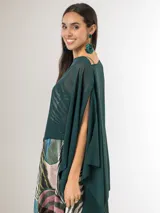 Capa midi verde oscuro confeccionada en gasa, con diseño asimétrico más corto en la parte delantera y más largo en la trasera, de caída liviana y fluida.