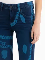 Jeans oxford de tiro medio-bajo, confeccionados en mezcla de algodón y elastano. Presentan un diseño ajustado hasta la rodilla y terminación acampanada, con un patrón gráfico de grabado láser cyanotype en tonos azules sobre base oscura.