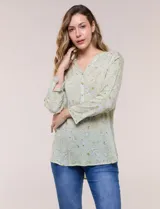 Blusa verde claro con estampado paisley, escote en V con botones frontales y manga larga.