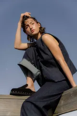 Zueco negro de cuero gamuza con plataforma forrada y tachas plateadas.