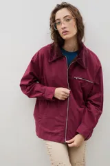 Campera de jean azul oscuro con cuello de pana en color crema. Presenta cierre frontal metálico, bolsillo con cierre en el pecho y bolsillos laterales. Diseño de corte holgado con mangas largas.