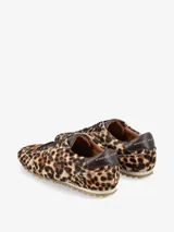 Zapatilla de estilo urbano con diseño de silueta clásica, confeccionada en cuero con textura de pelo natural y estampado animal print. Presenta cierre con cordones, refuerzo en el talón y suela dentada.