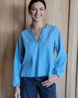 Blusa celeste de manga larga con escote en V y puños elásticos.