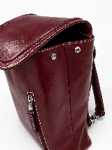 Mochila de cuero vacuno marrón con acabado pulido, solapa en forma de V y costuras decorativas. Cuenta con cremalleras laterales y asas ajustables.