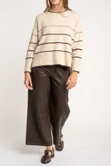 Sweater de punto con diseño de rayas horizontales en tonos neutros, cuello redondo, manga larga y puños acanalados.