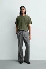 Camiseta de corte relajado, color verde oliva con efecto lavado. Presenta cuello redondo, manga corta y un gráfico estampado en la espalda.