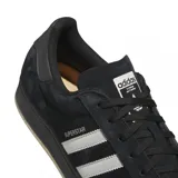 Championes Adidas modelo Superstar ADV, color negro con las icónicas tres tiras laterales en blanco. Presentan una capellada de gamuza, puntera de goma clásica y suela de goma con acabado oscuro.