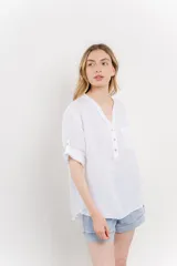 Camisa color topo confeccionada en lino, de corte holgado, con escote en V abotonado, bolsillo frontal y mangas 3/4 arremangables.