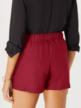 Short femenino color fucsia, de tiro alto con cintura elástica fruncida y lazo ajustable a tono. Presenta pliegues frontales y bolsillos laterales.