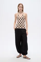 Top de punto al cuerpo con cuello halter, color beige con estampado de lunares marrones.