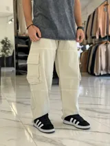 Pantalón cargo super baggy de jean color beige, de corte ancho con bolsillos laterales tipo cargo en las piernas y costuras reforzadas.