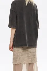 Camiseta de algodón negra con efecto gastado, corte oversize y mangas cortas anchas. Presenta un estampado frontal de un corazón dibujado con alambre de púas, conteniendo el texto "BIMBA LOLA" en su interior.