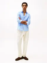 Camisa celeste de popelina de algodón con Flex Technology, corte regular, cuello abotonado, puños redondeados con dos botones, microestampado integral y logo de Tommy Hilfiger bordado en el pecho.