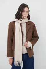 Blazer de gamuza color marrón, con solapas clásicas, cierre frontal de tres botones y bolsillos laterales con solapa.