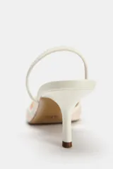 Zapato destalonado con tacón fino, color blanco. Capellada de mesh con bordados florales. Tira trasera elástica y punta fina. Tacón de 6 cm.