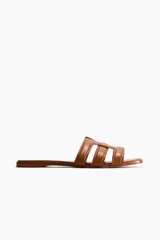 Sandalias planas de cuero marrón, con punta cuadrada y tiras superiores entrelazadas con diseño geométrico y acolchado.