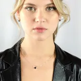 Collar dorado con cadena fina y dije circular negro.