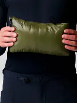 Campera puffer ultraligera de Mountain Hardwear, modelo Ghost Whisperer, color verde oliva. Confeccionada en tejido ripstop reciclado con aislamiento de plumón de 800 cuin con certificación RDS. Presenta cierre frontal completo, cuello alto, dos bolsillos laterales con cierre y puños con ribete elástico.