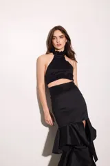 Top de tafeta color negro con escote halter y volados en el cuello, ajuste al cuerpo, espalda baja y cierre con botones.