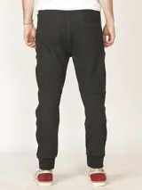 Pantalón de jogging color verde militar, corte slim, con puños elastizados en los tobillos y cordón ajustable en la cintura. Presenta un bolsillo lateral con cierre.