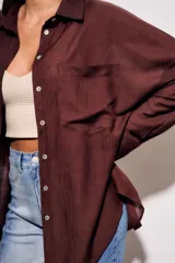 Camisa marrón de tencel y poliéster, corte oversize, manga larga y cierre con botones.