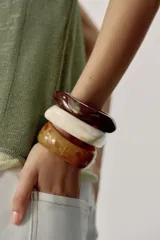 Pack de tres pulseras rígidas de resina en tonos tostado, marrón y beige, con diseño texturizado estilo carey y formas geométricas irregulares.