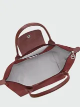 Mochila Longchamp modelo Le Pliage One, color bordó, con diseño minimalista, cierre superior y solapa frontal con botón a presión.
