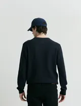 Sweater de punto con escote redondo, confeccionado en algodón con textura de punto fantasía en cuerpo y mangas, y terminaciones en punto canalé en cuello y puños.