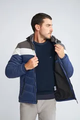 Campera inflada de abrigo para hombre, con capucha desmontable, cierre frontal completo, bolsillos con cierre y logo estampado. Diseño color block en azul, blanco y gris.