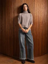 Poleron negro de tejido de punto con cuello alto doble y mangas 3/4 con puños acanalados.