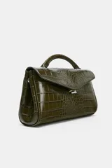 Bolso de mano de formato alargado con textura de efecto cocodrilo. Cuenta con asa de mano superior, asa extraíble para usar como bandolera, bolsillo interior con cierre y cierre frontal mediante clip metálico.