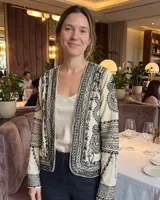 Chaqueta de algodón color crudo con bordados densos en tinta negra, de corte recto y mangas largas.