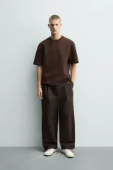 Sudadera de manga corta con corte relajado, confeccionada en tejido técnico compacto de algodón con elasticidad. Presenta cuello redondo y detalle de tacha metálica en la espalda.