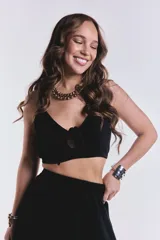 Top negro crop con tiras regulables, escote en V y detalle de nudo frontal con pequeña abertura.