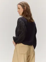 Remera blanca con cuerpo de algodón liso y mangas abullonadas semitransparentes con textura de lunares.