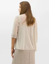 Vestido largo de encaje color beige, con escote recto decorado con pedrería y perlas, tirantes anchos y tajo lateral en la falda.