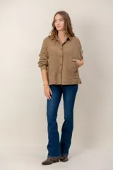 Campera de pana color tostado con diseño capitoneado en forma de rombos, cuello camisero, cierre frontal con botones y bolsillos delanteros.