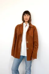 Blazer marrón de cuero gamuza con cuello clásico, solapas y cierre frontal con botones de cuerno.