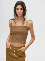 Top crop de tela denim con efecto fruncido, breteles finos ajustables con lazos y diseño entallado al cuerpo.